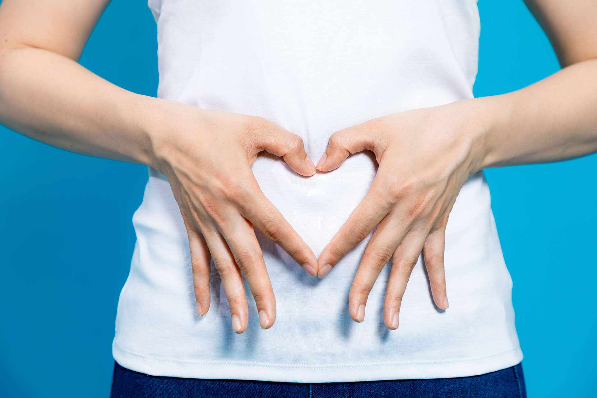 Hands forming a heart over the gut