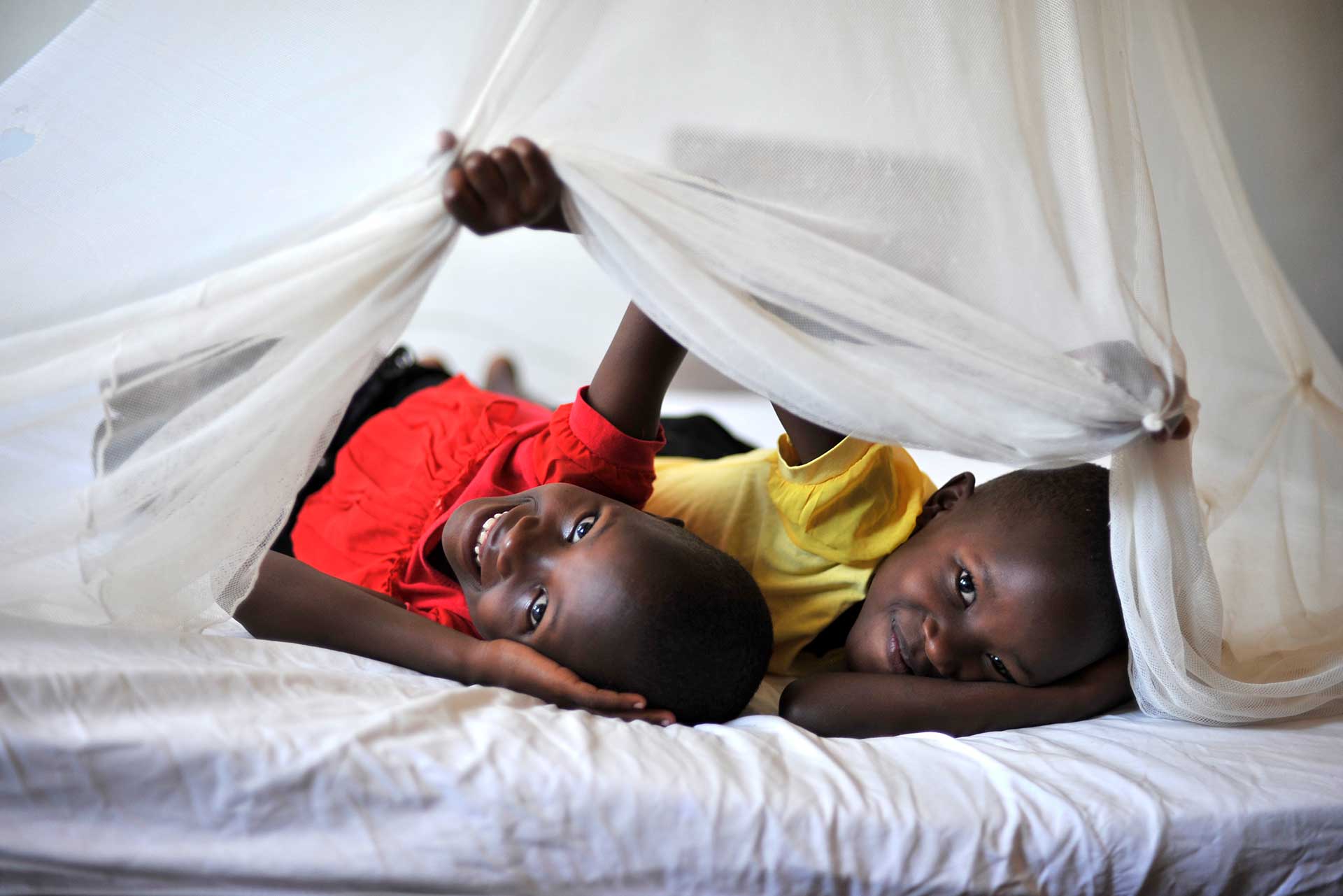 Two African children under a mosquito net